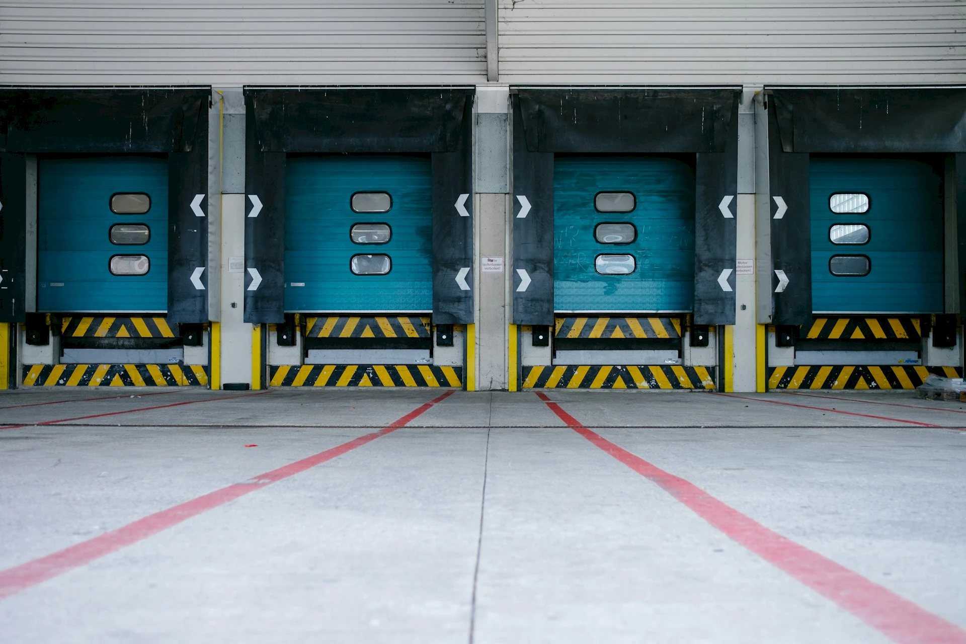 A loading dock with closed blue doors. Credit: Hannes Egler, Unsplash.