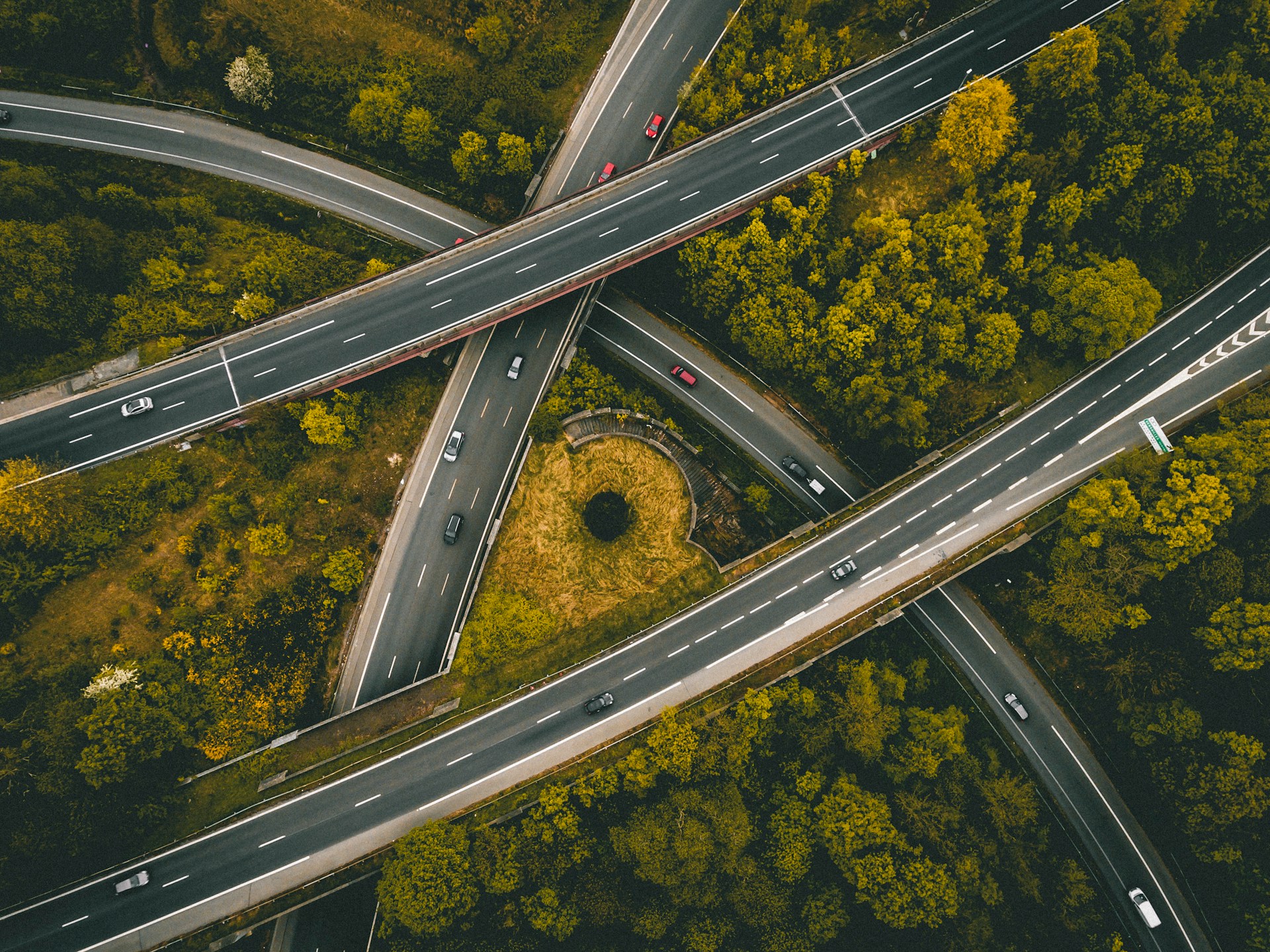 erial view of a complex highway interchange amidst trees, with cars on multiple roads. Credit: Ed 259, Unsplash.